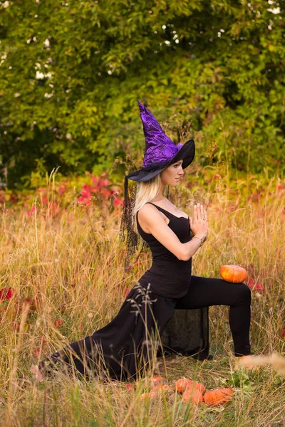 Mujer en traje de bruja practicando yoga —  Fotos de Stock