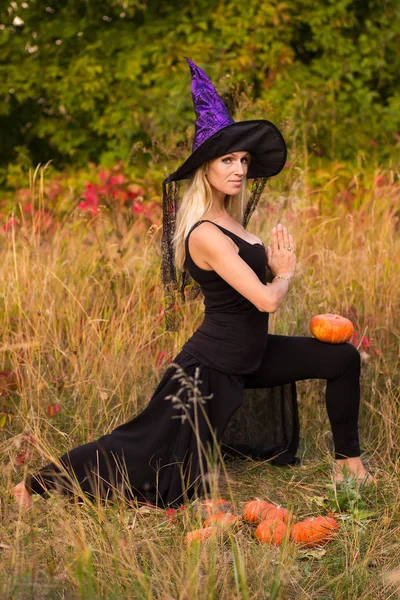 Hermosa mujer en traje de bruja practicando yoga —  Fotos de Stock