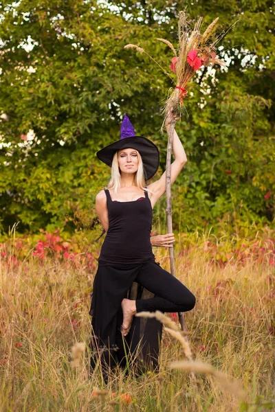 Menina bonita no traje de bruxa praticando ioga — Fotografia de Stock