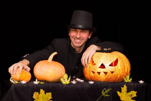 Asistente sonriente y un montón de calabazas de Halloween —  Fotos de Stock