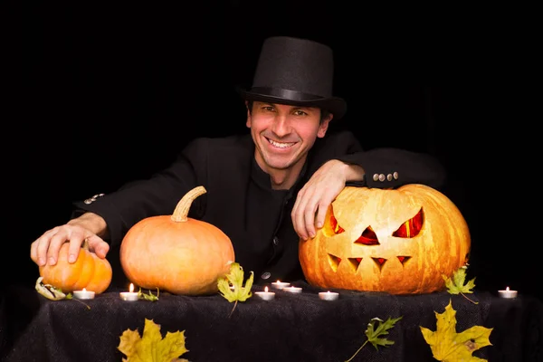 Feiticeiro sorridente e muitas abóboras de Halloween — Fotografia de Stock