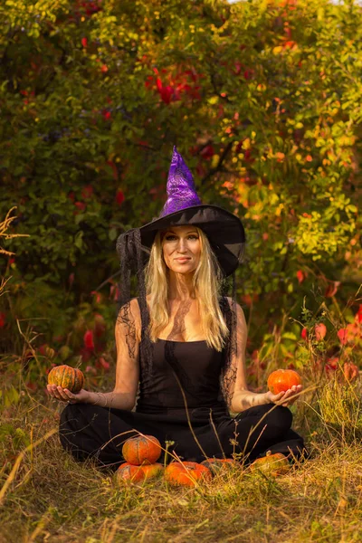 Niza hembra en traje de bruja practicando yoga — Foto de Stock