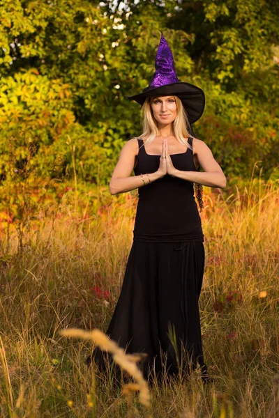 Feliz hembra en disfraz de Halloween practicando yoga —  Fotos de Stock