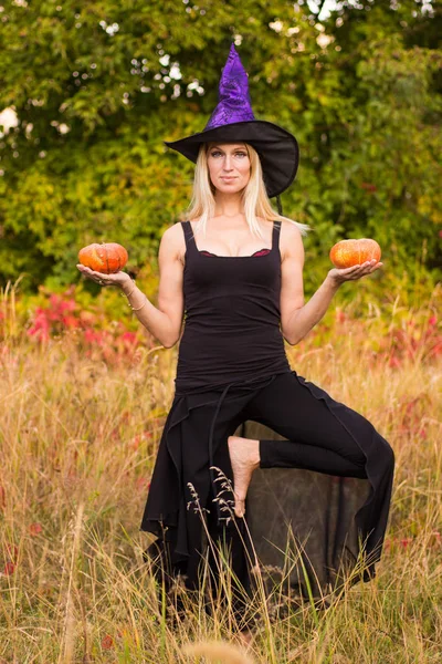 Mujer joven en traje de bruja practicando yoga —  Fotos de Stock