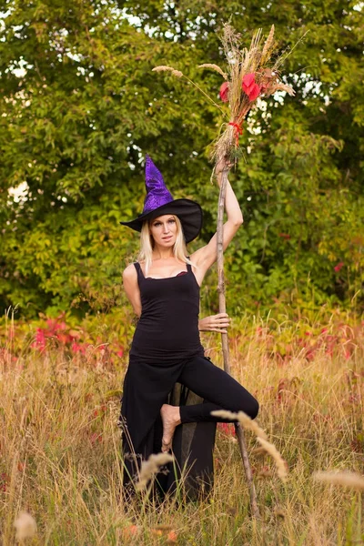 Fröhliche Frau im Hexenkostüm praktiziert Yoga — Stockfoto