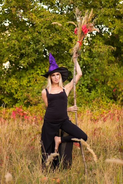 Mujer alegre en traje de bruja practicando yoga — Foto de Stock