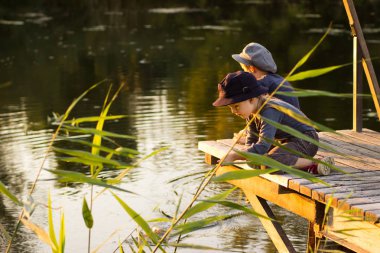 Elinde sopa ile oturan çocuk
