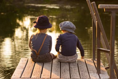 Elinde sopa ile oturan çocuklar