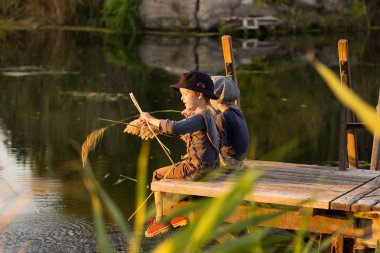 Neşeli çocuklar ellerinde sopalarla oturan