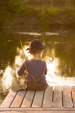 Elinde sopa ile oturan çocuk