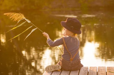 Elinde sopa ile oturan sıradan bir çocuk