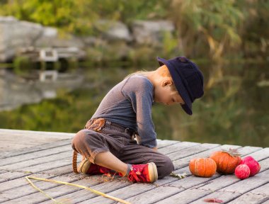 Halloween pumpkins ile oturan boy gülümseyerek