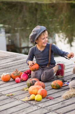 Gülen çocuk Halloween pumpkins ile oturan