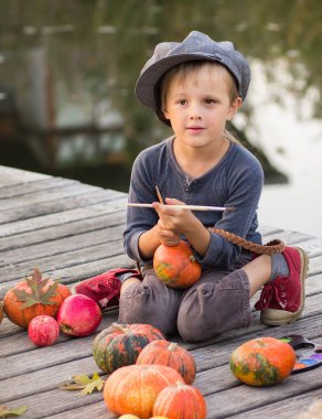Neşeli çocuk Halloween pumpkins ile oturan