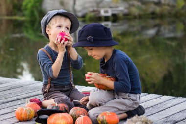 Neşeli çocuklar kabak ve elma ile oturan
