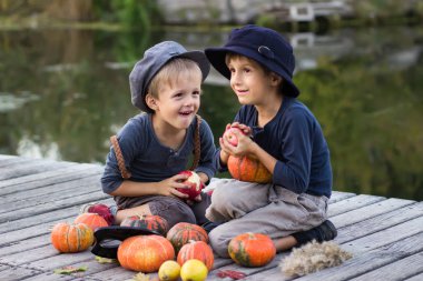 Kabak ve elma ile oturan çocuklar gülüyor