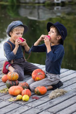 Kabak ve elma ile oturan dostu çocuklar