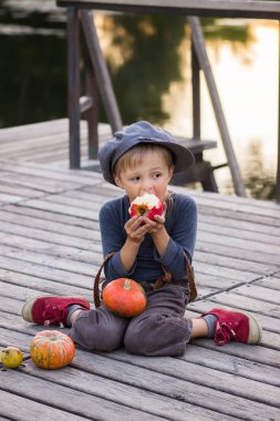 Kabak ve elma ile oturan çocuk