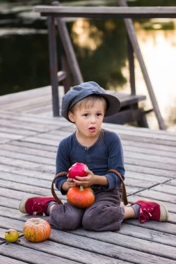Kabak ve elma ile oturan sıradan bir çocuk