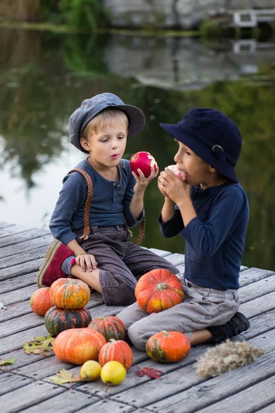 Kabak ve elma ile oturan çocuklar