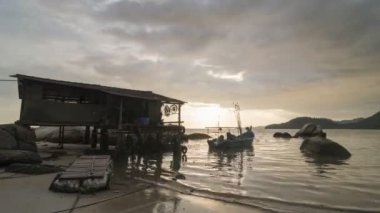 Balıkçı kulübe sahil yakınındaki Timelapse şaşırtıcı günbatımı.