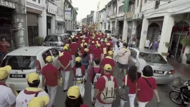 High angle devotees in red shirt walk on the road. — Stock Video