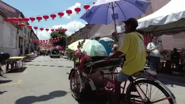 Fietstaxi bestuurder onderhoudt bezoeker op Cannon Street, Penang. — Stockvideo