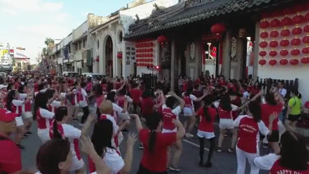 Μια ομάδα γυναικών φορούν κόκκινο πουκάμισο χορό μπροστά από ναό κατά τη διάρκεια του κινεζικού νέου έτους — Αρχείο Βίντεο