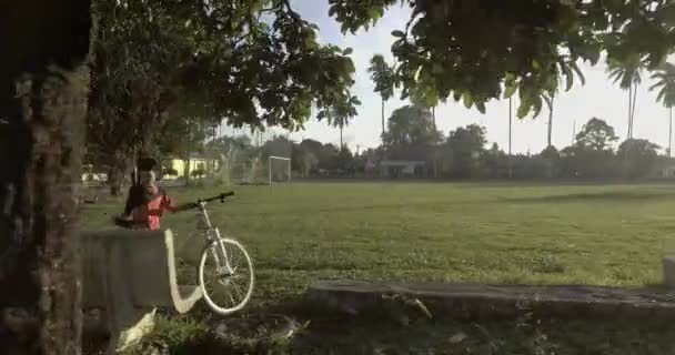 Tracking shot av fotbollsplan. Vissa människor cykla och spela fotboll, — Stockvideo
