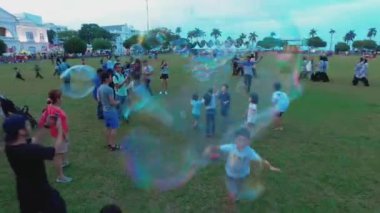 PENANG, MALAYSIA - 10 Mart 2018: Çocuklar Padang Kota Lama, Penang 'da baloncukları kovalıyor.