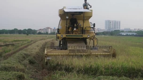 BUKIT MERTAJAM, MALAYSIA - MARCH 28, 2018: Farmers using the New Holland harvester to cut the rice paddy field.
