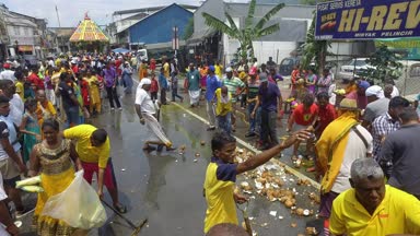 BUKIT MERTAJAM, MALAYSIA - 30 Mart 2018: Hayranlar hindistan cevizini kırıyor ve işçiler aynı anda hindistan cevizini temizliyorlar.