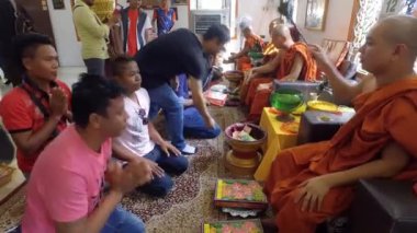 PENANG, MALAYSIA - 13 Nisan 2018: Dharmikarama Burma Tapınağı 'ndaki Songkran festivali sırasında rahibin önünde namaz kılanlar.
