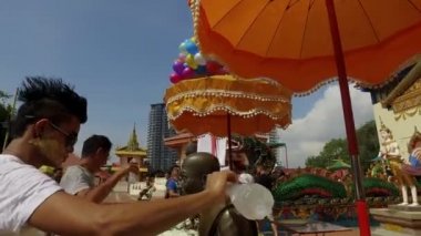 PENANG, MALAYSIA - 13 Nisan 2018: Wat Chayamangkalaram Tayland Budist Tapınağı 'ndaki tören kapsamında insanlar Buda resimlerinin üzerine su döküyor. .