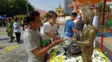 Wat Chayamangkalaram Thai Budist Tapınağı 'ndaki Songkran şenliği sırasında vücuduna su döküldü...