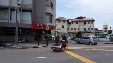 George Town, Penang / Malezya - 30 Mayıs 2018: Trishaw sürücüsü Penang Yolu 'ndaki park alanına geri dönüyor.