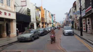 George Town, Penang / Malezya-Haziran 01-2018: Campbell Caddesi boyunca bisiklet süren yaşlı bir kadın.