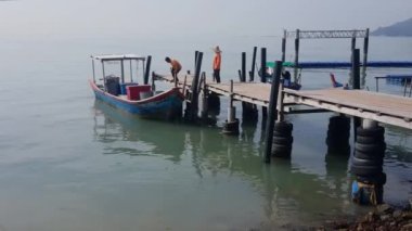 George Town, Penang / Malezya-Haziran 05: 2018: Balıkçılar balıkları takım çalışması ile iskeleye aktarıyor.