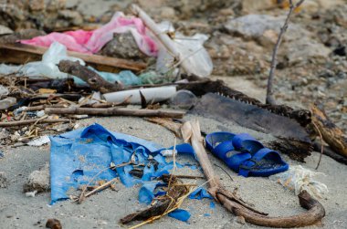 Çöp plastiği, sandaletler deniz kıyısındaki çöpler..