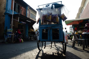 Roti adam trishaw caddede.