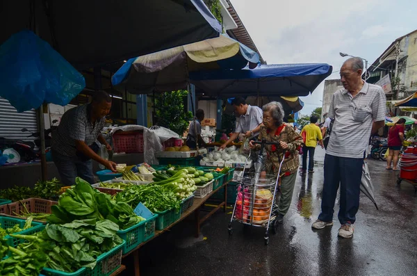 La gente compra las verduras en el mercado húmedo por la mañana . — Foto de Stock