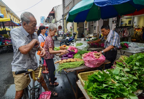 La gente compra verduras en el mercado húmedo en la calle . — Foto de Stock