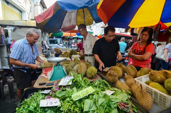 Hawker vende durian durante la temporada en el mercado húmedo al lado de las verduras . — Foto de Stock