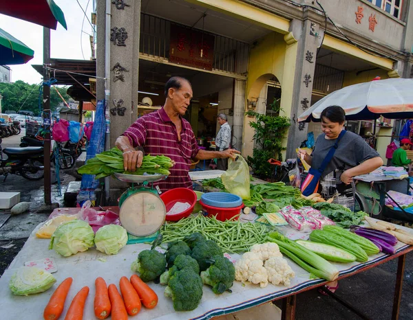 Los vendedores ambulantes venden verduras en el mercado húmedo mornign . — Foto de Stock