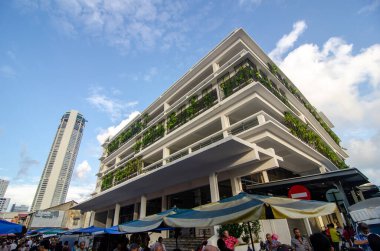 Arka planda yeşil santralli Chowrasta pazarı ve KOMTAR binası.