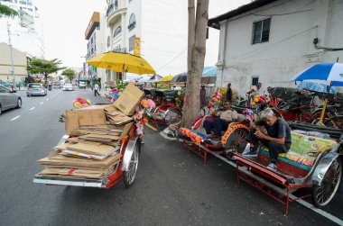 Rickshaw sürücüsü sokakta dinleniyor..