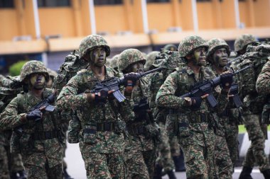 Merdeka geçit töreninde askerler silah taşıyor.