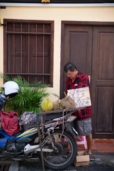 Un hombre lleva a Musang King Durian y vende a motor . —  Fotos de Stock