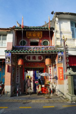 Bir adam bisikletle Hock Teik Cheng Sin Tapınağının girişine doğru gidiyor.