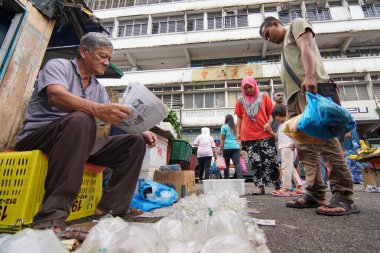 Beta balık satıcısı sabah pazarında gazete okur..